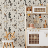 Kids' play kitchen setup with Howdy Partner cartoon cowboy wallpaper, showing illustrations of cowboys, horses, and Western elements like cacti and cowboy boots on the wall