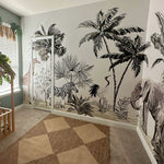 Safari-themed nursery room with a mural featuring zebras, giraffes, palm trees, and elephants. Natural wood crib with tropical bedding and leafy decorations. A cozy, playful space for a child