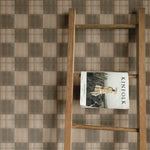 Rustic wooden ladder against a wall adorned with Mediterranean tile wallpaper, adding texture and elegance to a neutral, earthy space