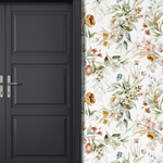 A stylish black door contrasting against a wall with vibrant watercolor floral wallpaper, creating a chic entryway.