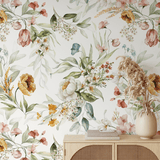 An elegant home interior featuring a wooden cabinet against a watercolor floral wallpaper, adorned with a vase of dried flowers.