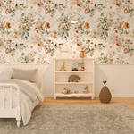 A children's bedroom adorned with vibrant floral wallpaper showcasing large blooms in shades of pink, yellow, and blue with lush green foliage. A cozy bedroom corner highlighting wallpaper with a rich array of flowers and leaves in soft watercolor tones of peach, mustard, and sage.