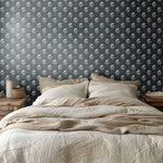 Minimalist bedroom with navy blue floral wallpaper, cream bedding, and wooden furniture for a timeless look