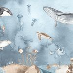 Ocean mural wallpaper designed for a child's room or nursery, showing a detailed and realistic sea life scene with creatures like orcas, whales, rays, and jellyfish, all set against a tranquil blue watercolor background. The mural offers a serene underwater world, perfect for a coastal-inspired kids' bedroom or a marine-themed play space.