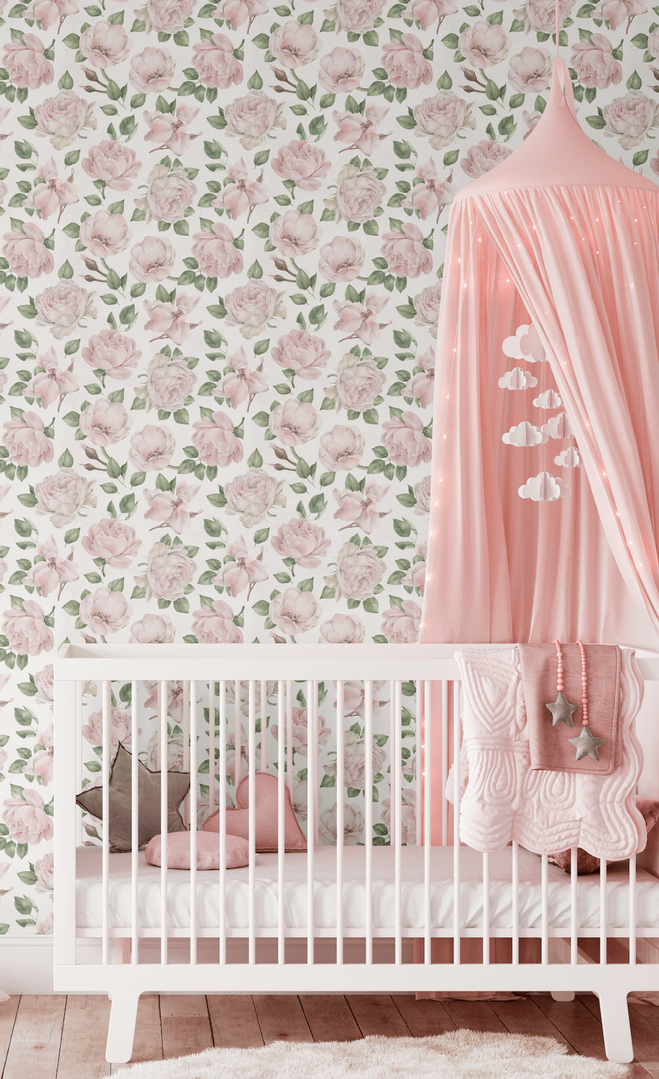 A cozy nursery room with a white crib adorned with a pink star pillow and a heart-shaped pillow, set against a wall covered in pink rose-patterned wallpaper. A pink canopy with cloud-shaped decorations hangs over the crib, adding a dreamy touch to the room.