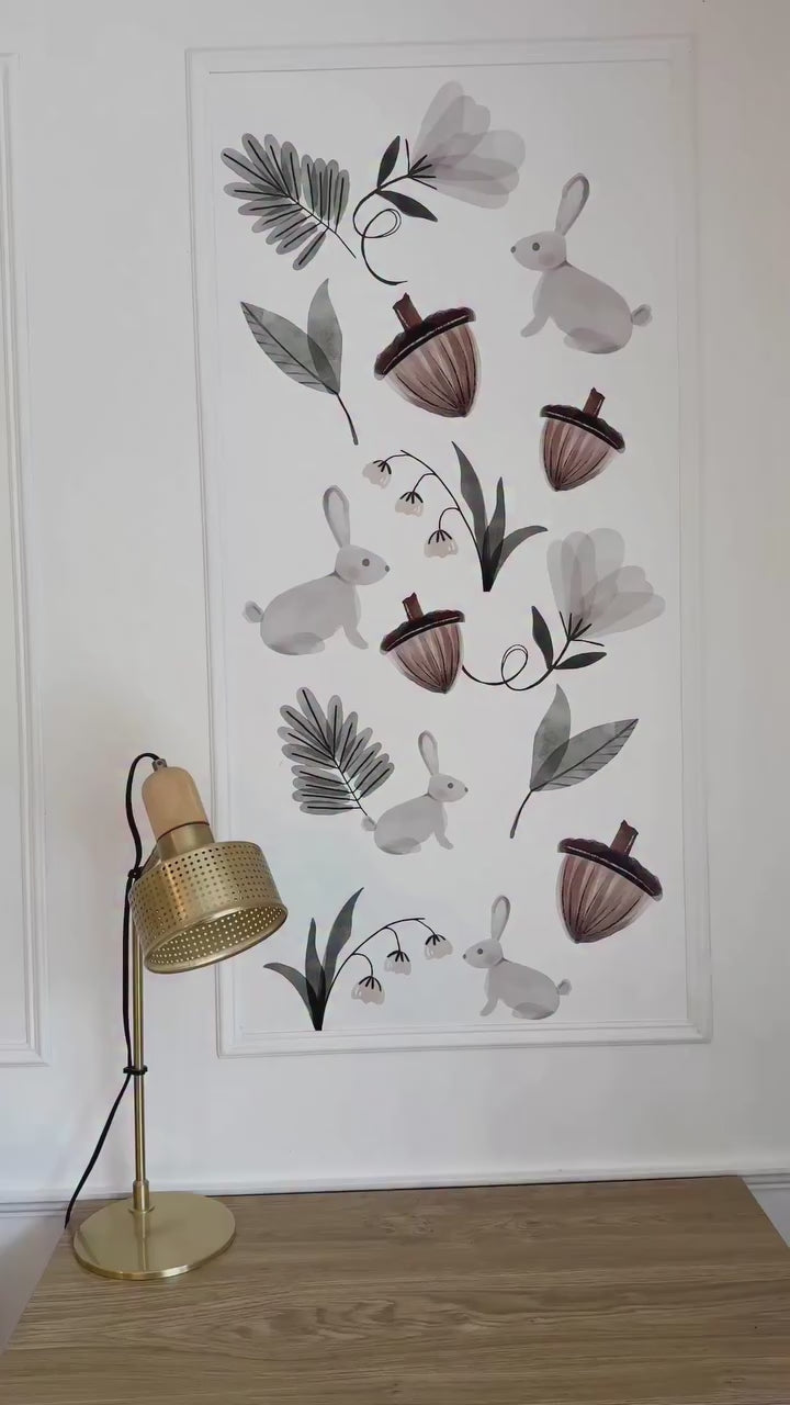 Placing the Enchanted Rabbit decals on a wall. Decals include cute acorn, floral decals, and leaf decals with the rabbits. 