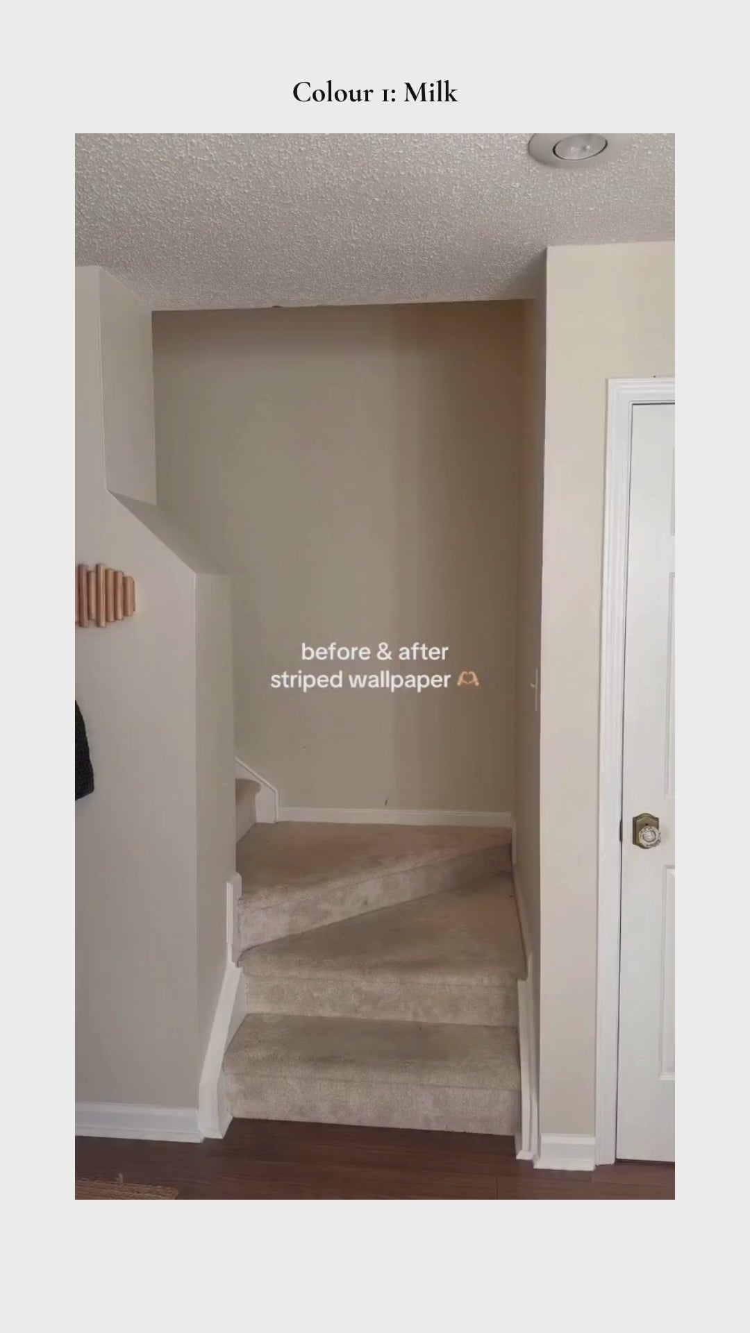 Brown striped wallpaper in stairwell with wedding photos framed on wall.