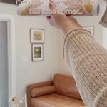 Let's use some golden meadow flower decals in this corner... video shows unrolling daisy decals and placing them on a wall. Styled with a brown leather couch. Very beautiful! 