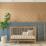 Rustic nursery with Racing Pony wallpaper, wooden crib, and green plant.