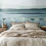 Tranquil blue water-inspired mural in a nature-themed bedroom with natural wood nightstands.