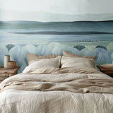 Tranquil blue water-inspired mural in a nature-themed bedroom with natural wood nightstands.