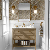 A stylish bathroom with white wainscoting featuring a floral wallpaper with brown and olive green flowers on a beige backdrop, complementing the gold-framed mirror and fixtures.