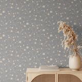 Styled room featuring our Winter floral peel and stick wallpaper, showcasing delicate patterns of flowers and leaves on a grey background, paired with a neutral-toned wooden sideboard and dried pampas grass in a vase