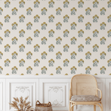 Vintage yellow floral block print wallpaper in a rustic living room with white wainscoting and a rattan chair.