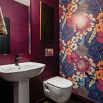 Vibrant wallpaper floral peel and stick wallpaper in a bathroom with red paint walls