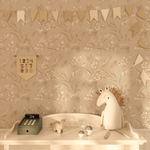 A nursery shelf with playful decor against a beige peel and stick wallpaper with a whimsical forest animal pattern