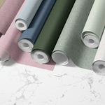Faux grasscloth wallpaper rolls, featuring a variety of colors including brown, purple, cream, pink, light blue, navy, forest green, sage green and charcoal