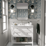 A bathroom with the walls covered in a woodland-themed wallpaper showcasing white rabbits, trees, and birds on a blue background. 
