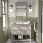 Elegant bathroom with faded blush neutral wallpaper featuring a subtle floral design above green wainscoting.