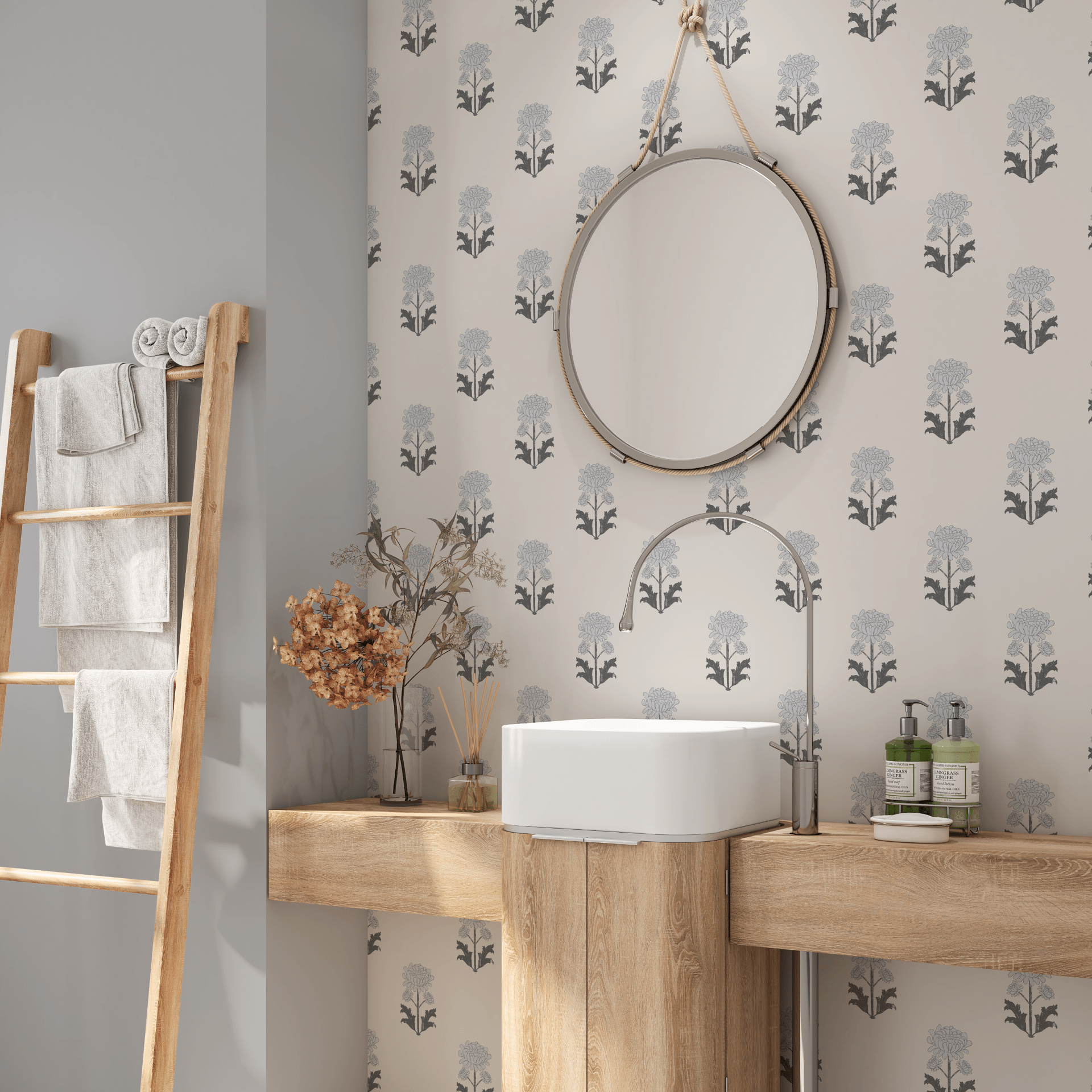 A modern bathroom with a wall adorned in floral blueprint self-adhesive wallpaper. A round mirror hangs above a wooden vanity with a white basin, complemented by dried flowers and soft towels on a ladder rack beside it