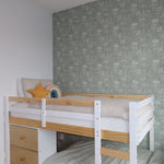 A child's bedroom featuring a white and pine bunk bed against a forest green wallpaper with a subtle floral pattern and a stuffed triceratops head wall decor.
