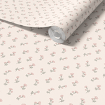 Close-up of wallpaper roll with pink flower pattern.