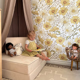 Little girl sits in her bedroom reading a book with beautiful yellow wallpaper and subtle room decor