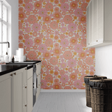 Modern laundry room design featuring retro floral removable self-adhesive wallpaper, creating a lively and cheerful backdrop against the contrast of white cabinetry and dark countertops.