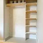 Bedroom closet renovated using natural would accents over a grey and white Scandinavian style peel and still wallpaper