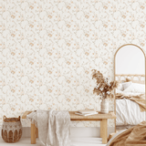 Bedroom with whimsical blossom peel and stick wallpaper in a soft, neutral palette complementing a cozy bed and bench.