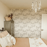 Horse wallpaper in a bedroom with neutral bedding, green armoire and white chandelier. Peel and Stick wild horse wallpaper